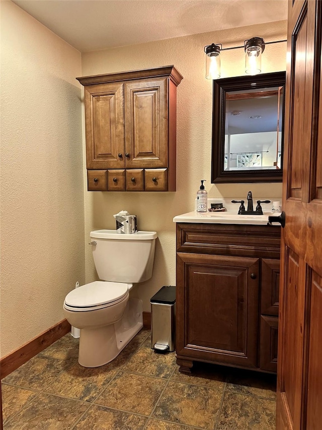 85 Osprey Dr E, Thompson Falls, MT 59873 - half bath featuring toilet, baseboards, vanity, and stone finish flooring
