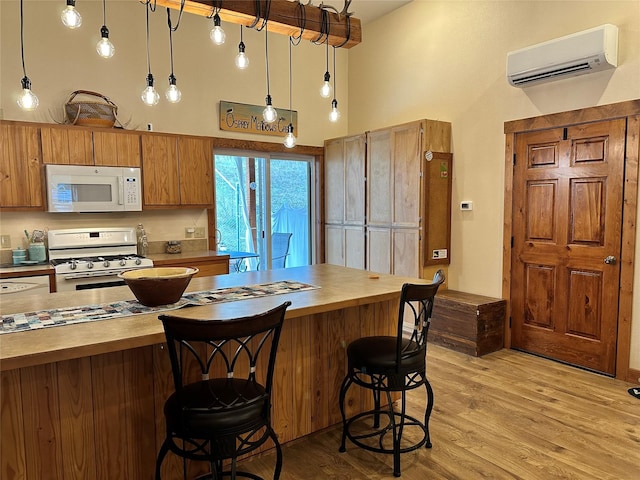 85 Osprey Dr E, Thompson Falls, MT 59873 - kitchen featuring white appliances, an AC wall unit, wooden counters, a towering ceiling, and brown cabinets
