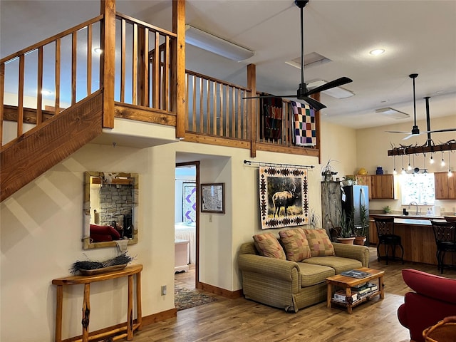 85 Osprey Dr E, Thompson Falls, MT 59873 - living room featuring a ceiling fan, wood finished floors, stairway, baseboards, and a fireplace