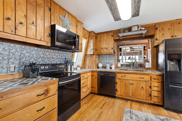 44688 N Foothills Dr, Ronan, MT 59864 - kitchen with black appliances, tile counters, a sink, decorative backsplash, and light wood-style flooring