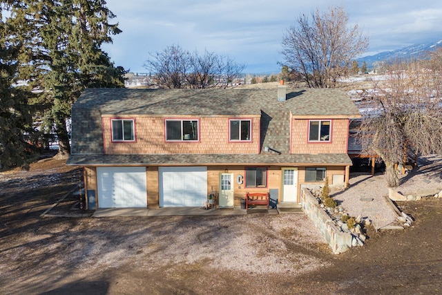 44688 N Foothills Dr, Ronan, MT 59864 - view of front facade featuring a shingled roof, dirt driveway, a chimney, and a garage