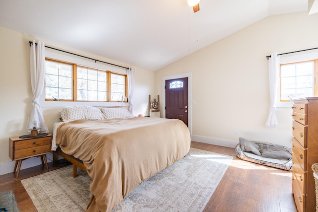 bedroom featuring baseboards, wood finished floors, vaulted ceiling, and a ceiling fan