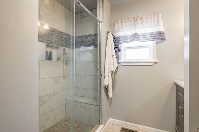 bathroom with vanity, baseboards, visible vents, and a stall shower