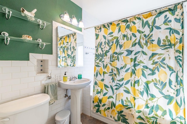 bathroom featuring tile walls, a sink, and toilet