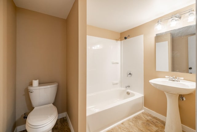 full bath featuring toilet, a sink, shower / tub combination, and baseboards