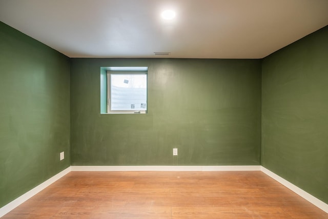 empty room featuring visible vents, baseboards, and light wood-style floors