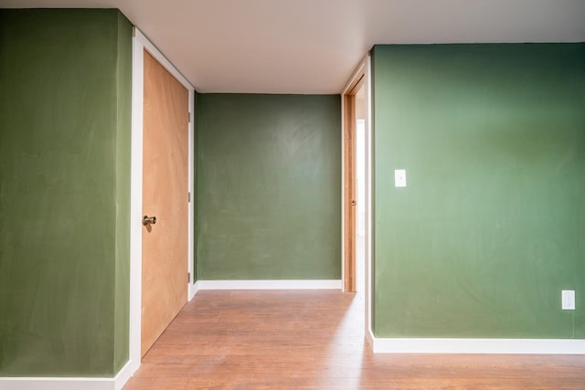 hallway with baseboards and light wood-style floors