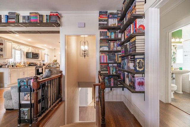 hall featuring ornamental molding, visible vents, and wood finished floors