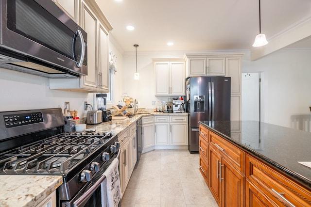 kitchen with dark stone countertops, decorative light fixtures, ornamental molding, appliances with stainless steel finishes, and brown cabinets