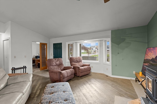 385 Meadow Hills Dr, Kalispell, MT 59901 - living room featuring vaulted ceiling, wood finished floors, and a wood stove