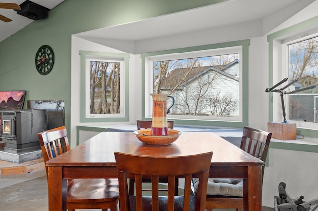 385 Meadow Hills Dr, Kalispell, MT 59901 - dining space featuring a wood stove, concrete floors, and lofted ceiling