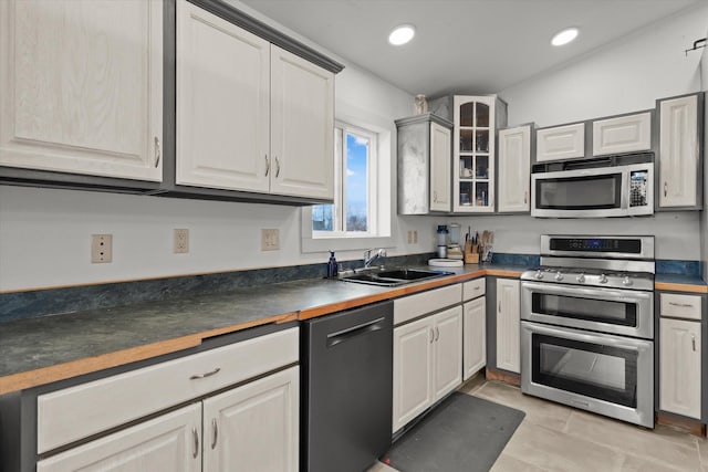 385 Meadow Hills Dr, Kalispell, MT 59901 - kitchen with stainless steel appliances, dark countertops, glass insert cabinets, and recessed lighting