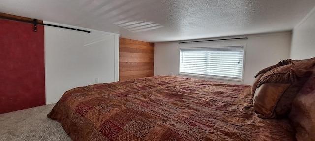 20795 Whispering Pines Rd, Missoula, MT 59808 - carpeted bedroom featuring a barn door and wood walls