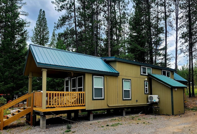 20795 Whispering Pines Rd, Missoula, MT 59808 - view of side of property with a metal roof, a wooden deck, and view of scattered trees