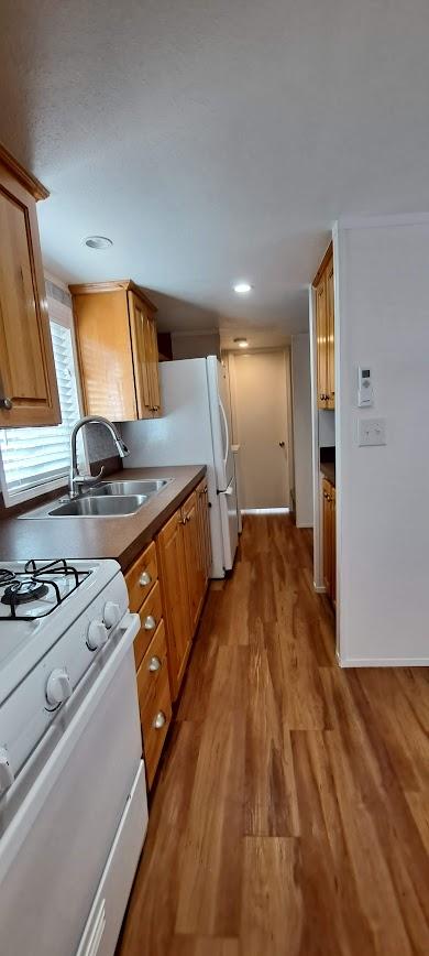 20795 Whispering Pines Rd, Missoula, MT 59808 - kitchen featuring gas range gas stove, wood finished floors, and brown cabinetry