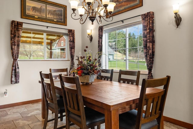 8 Primrose Ct, Kalispell, MT 59901 - dining area with baseboards, a chandelier, and light stone finish flooring