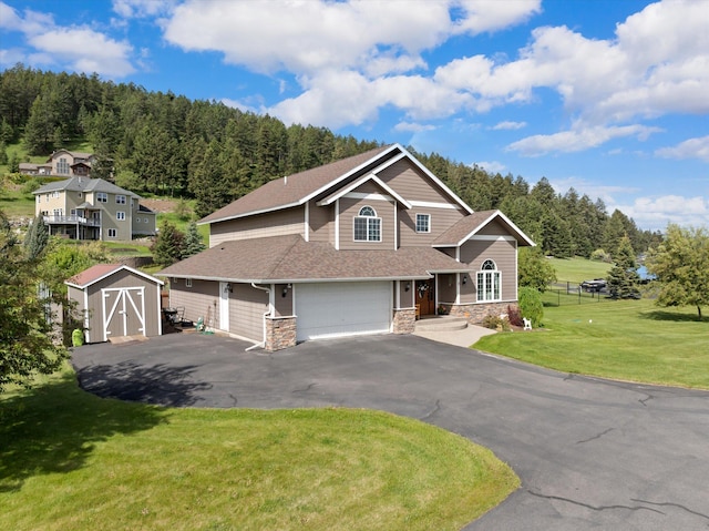8 Primrose Ct, Kalispell, MT 59901 - craftsman-style house with stone siding, a front yard, a view of trees, asphalt driveway, and a garage