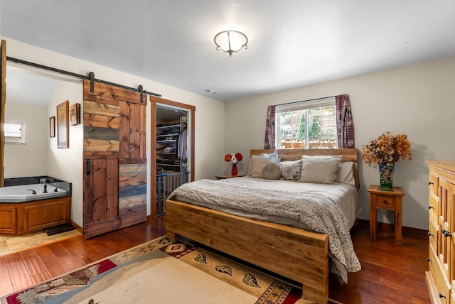 8 Primrose Ct, Kalispell, MT 59901 - bedroom with a barn door, dark wood finished floors, a walk in closet, and a closet