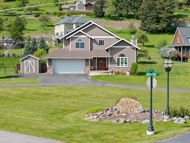 8 Primrose Ct, Kalispell, MT 59901 - view of front of property featuring stone siding, a garage, a chimney, and asphalt driveway