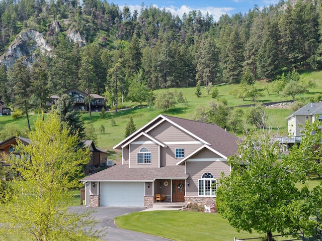 8 Primrose Ct, Kalispell, MT 59901 - view of front facade with stone siding, an attached garage, asphalt driveway, a front lawn, and roof with shingles
