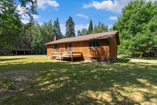 220 Ferndale Dr, Bigfork, MT 59911 - back of house with a wooden deck, a lawn, and a chimney