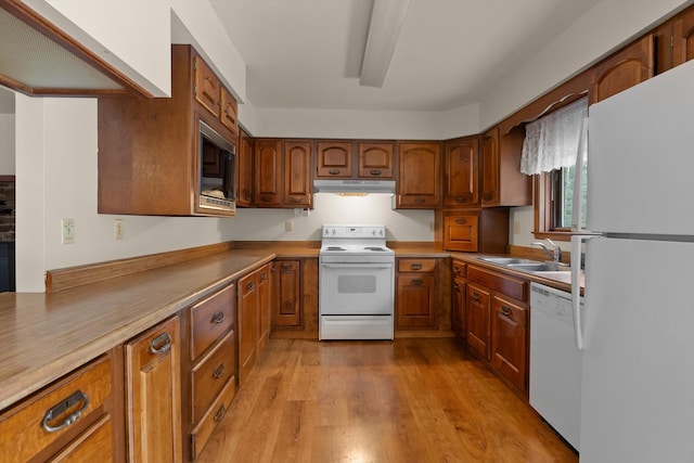 220 Ferndale Dr, Bigfork, MT 59911 - kitchen featuring white appliances, under cabinet range hood, brown cabinets, and light wood-style flooring