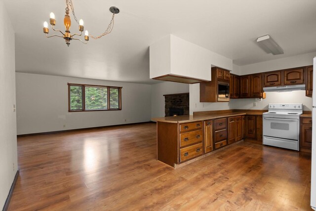 220 Ferndale Dr, Bigfork, MT 59911 - kitchen with white electric range, under cabinet range hood, open floor plan, a chandelier, and a peninsula