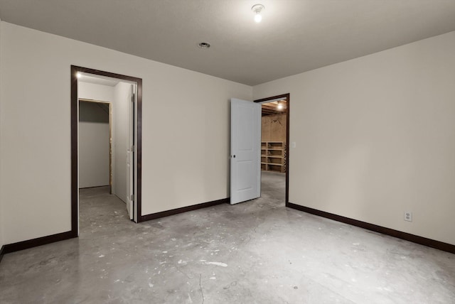 220 Ferndale Dr, Bigfork, MT 59911 - unfurnished bedroom with a spacious closet, unfinished concrete flooring, and a closet