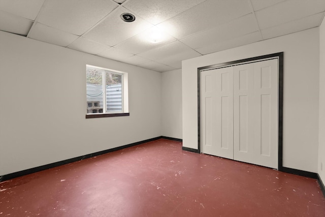220 Ferndale Dr, Bigfork, MT 59911 - unfurnished bedroom featuring a drop ceiling, finished concrete floors, and a closet