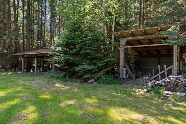 220 Ferndale Dr, Bigfork, MT 59911 - view of grassy yard featuring a pole building, an outdoor structure, and a wooded view