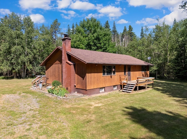 220 Ferndale Dr, Bigfork, MT 59911 - rear view of property featuring a lawn, a chimney, a deck, and a view of trees