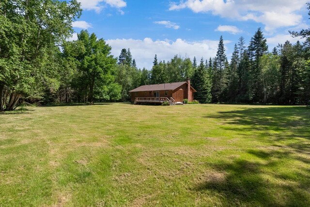 220 Ferndale Dr, Bigfork, MT 59911 - view of grassy yard with a deck and a view of trees