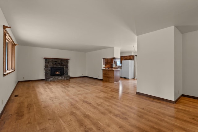 220 Ferndale Dr, Bigfork, MT 59911 - unfurnished living room featuring light wood finished floors and a fireplace
