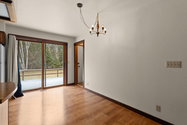220 Ferndale Dr, Bigfork, MT 59911 - unfurnished dining area featuring a chandelier and light wood-type flooring