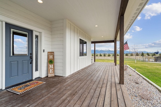 2650 W Valley Dr, Kalispell, MT 59901 - wooden deck featuring a lawn, a rural view, a mountain view, and fence