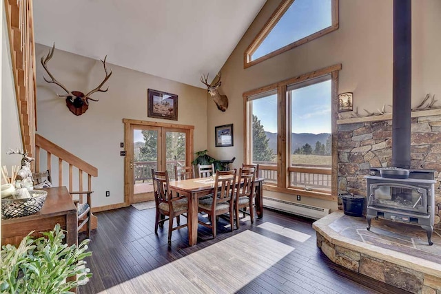 5 Alpine Valley Ln, Clancy, MT 59634 - dining space with a baseboard heating unit, high vaulted ceiling, dark wood-type flooring, a mountain view, and a wood stove