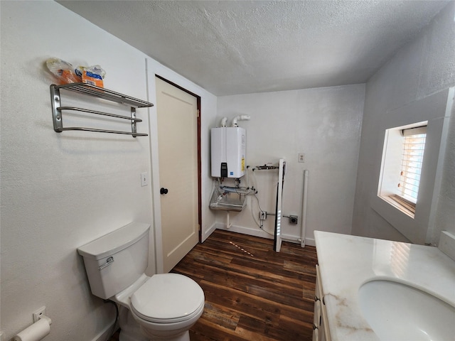 105 Stapp Ln, Darby, MT 59829 - bathroom with a textured ceiling, vanity, toilet, wood finished floors, and tankless water heater