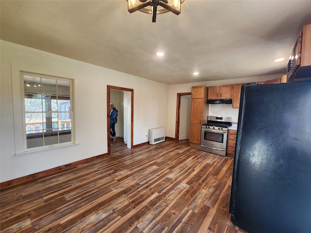 105 Stapp Ln, Darby, MT 59829 - kitchen with freestanding refrigerator, a ceiling fan, stainless steel range with gas cooktop, under cabinet range hood, and brown cabinets