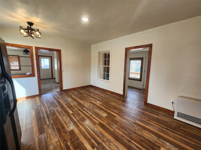 105 Stapp Ln, Darby, MT 59829 - interior space with a chandelier, a textured ceiling, dark wood-style flooring, and baseboards
