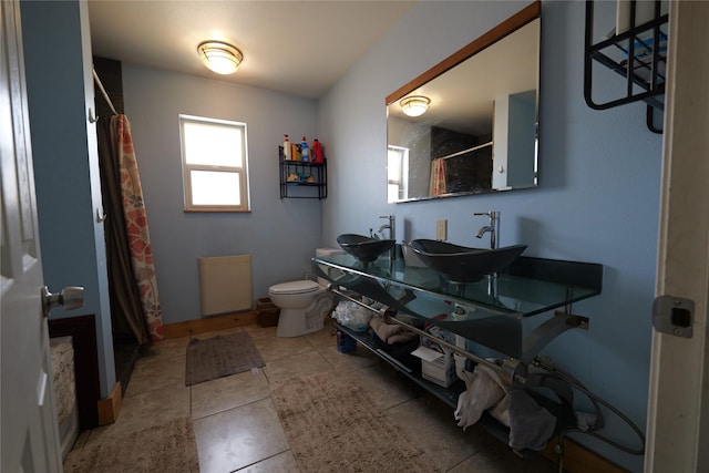 261 Locust Ln, Seeley Lake, MT 59868 - full bathroom with toilet, curtained shower, double vanity, and tile patterned flooring