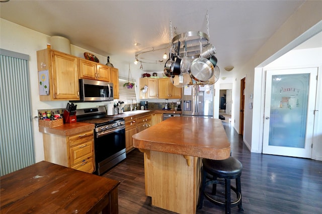 261 Locust Ln, Seeley Lake, MT 59868 - kitchen featuring appliances with stainless steel finishes, dark wood finished floors, a center island, and light brown cabinets