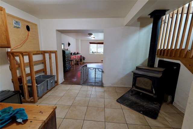 261 Locust Ln, Seeley Lake, MT 59868 - living area with a wood stove, light tile patterned floors, and baseboards