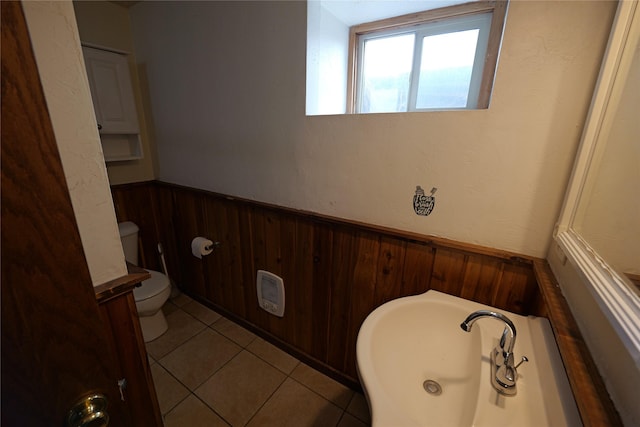 261 Locust Ln, Seeley Lake, MT 59868 - bathroom with wainscoting, tile patterned flooring, toilet, a bathtub, and wooden walls