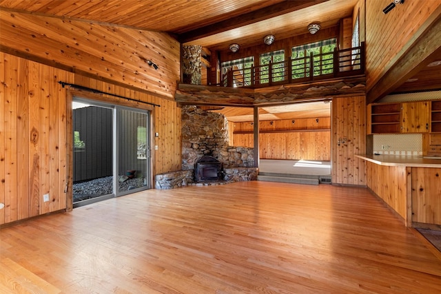 2041 Sleeping Child Rd, Hamilton, MT 59840 - unfurnished living room with wood finished floors, wood walls, a high ceiling, a wood stove, and a wooden ceiling with exposed beams