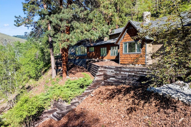2041 Sleeping Child Rd, Hamilton, MT 59840 - view of front facade with a chimney and a view of trees