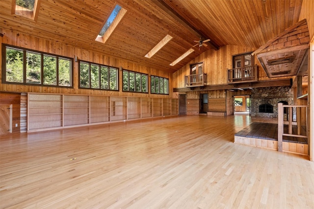2041 Sleeping Child Rd, Hamilton, MT 59840 - unfurnished living room featuring wooden walls, a wood ceiling with exposed beams, plenty of natural light, a skylight, and wood finished floors