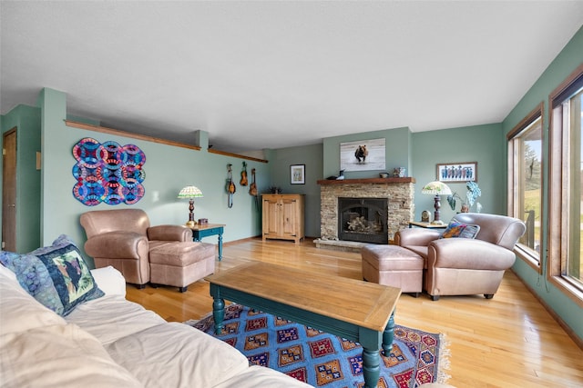 living room featuring a fireplace, wood finished floors, and a healthy amount of sunlight