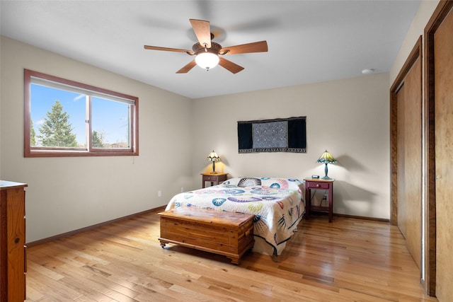 bedroom with baseboards, a ceiling fan, and light wood-style floors