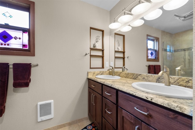 full bathroom with a tile shower, a sink, and a wealth of natural light
