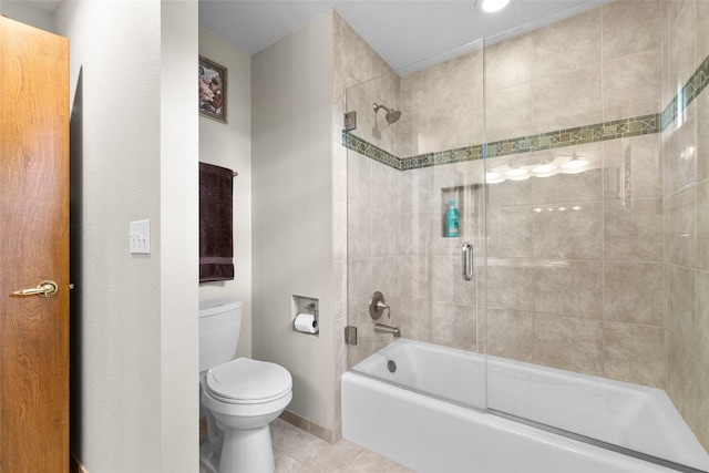full bath with combined bath / shower with glass door, toilet, tile patterned flooring, and baseboards